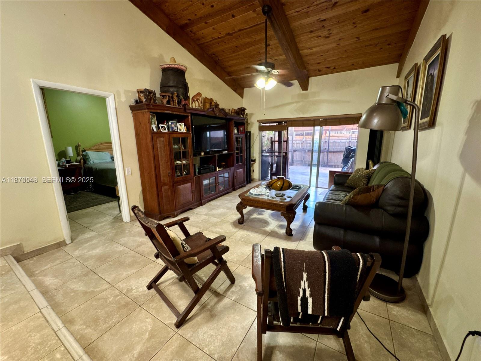 13527 Southwest 101st Lane Miami, FL 33186 - Photo 14 of 45 a living room with furniture a flat screen tv and a table
