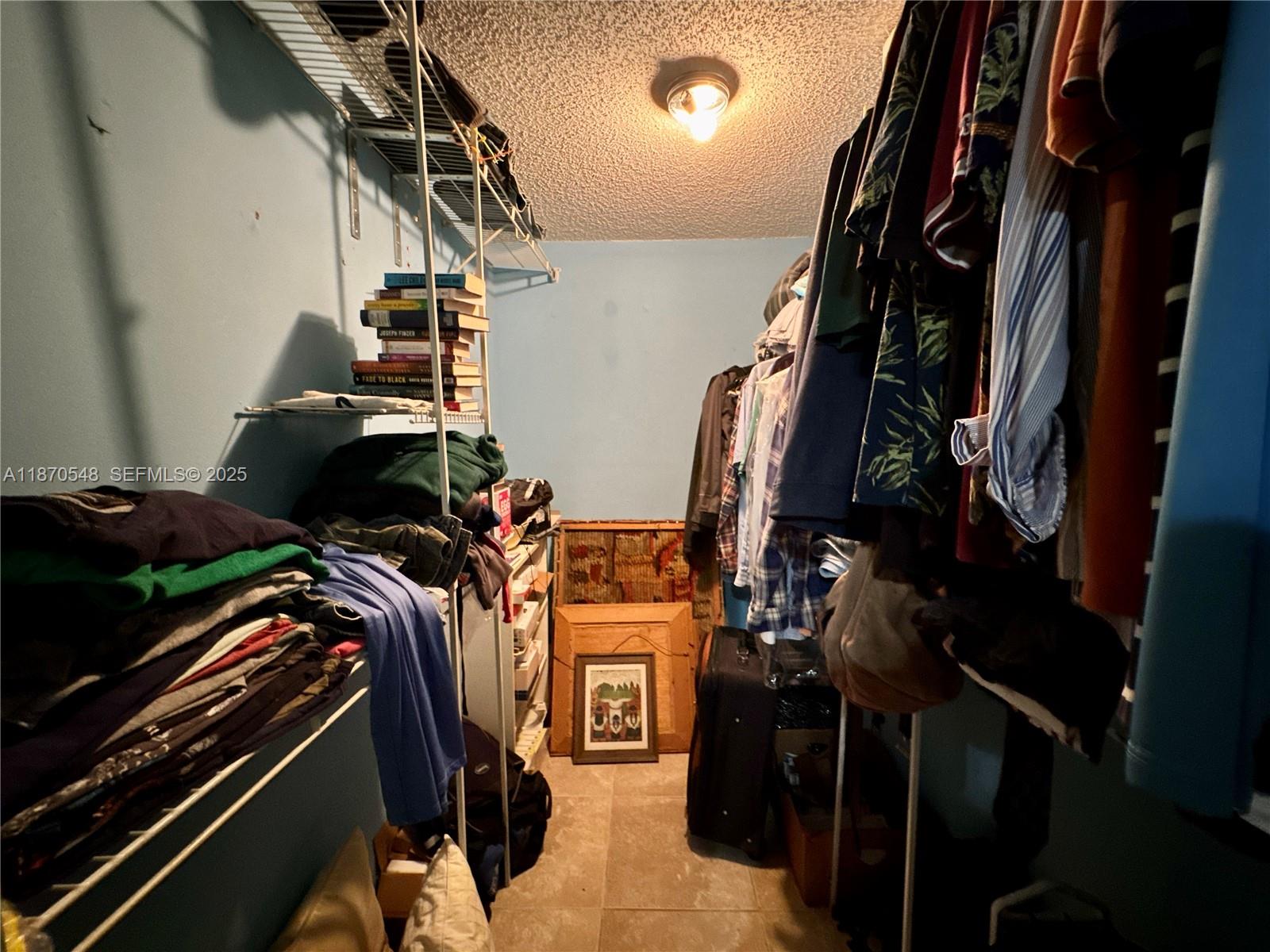 13527 Southwest 101st Lane Miami, FL 33186 - Photo 24 of 45 a view of walk in closet with clothes and shoes