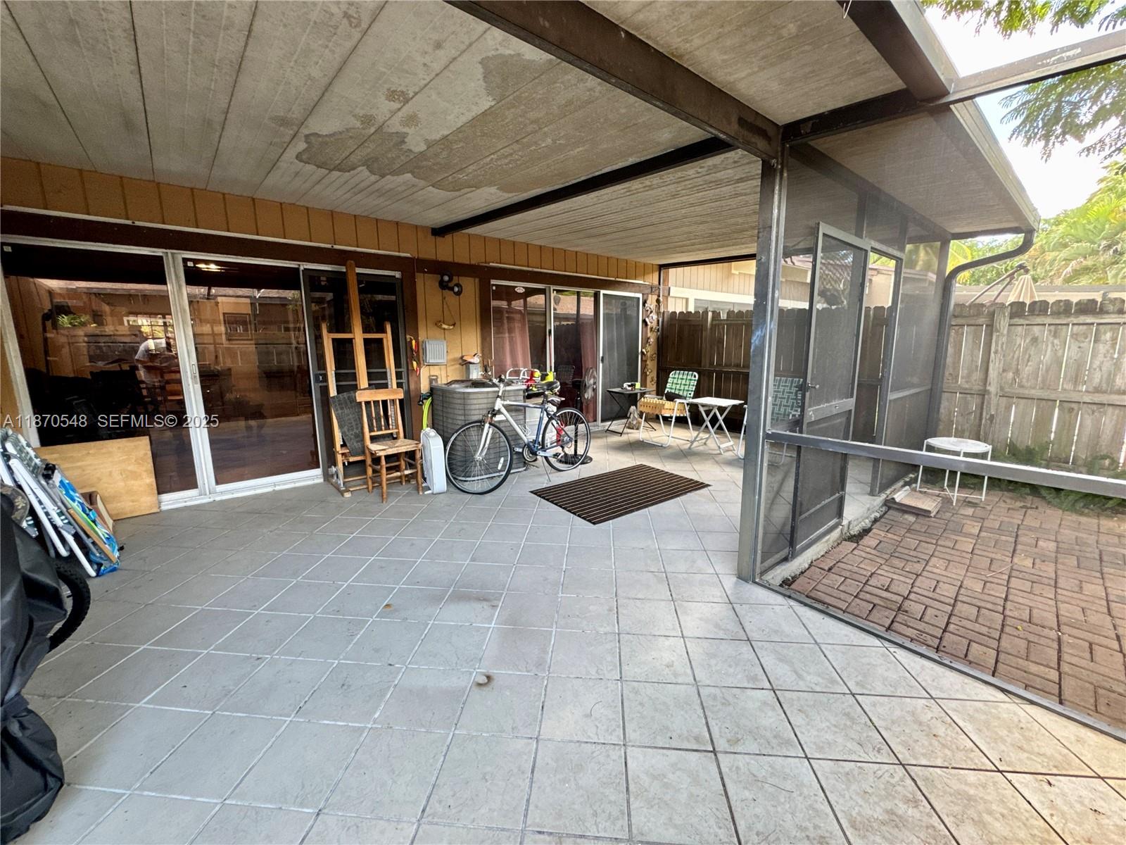 13527 Southwest 101st Lane Miami, FL 33186 - Photo 27 of 45 a view of a patio with table and chairs with wooden floor and plants
