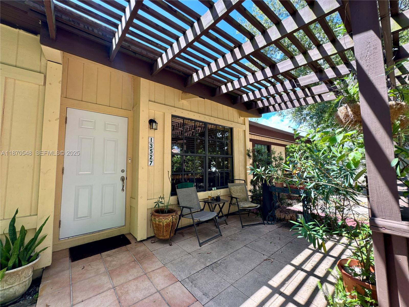 13527 Southwest 101st Lane Miami, FL 33186 - Photo 5 of 45 a view of a porch with furniture and potted plants