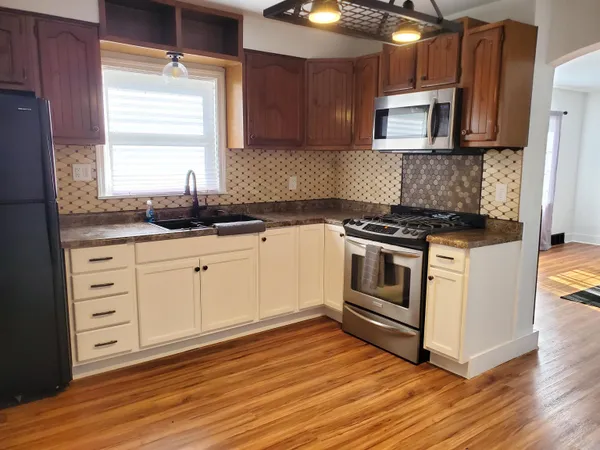 a kitchen with granite countertop a stove a sink and a microwave