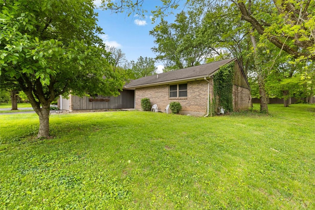 7225 Garber Road Clayton, OH 45415 - Photo 7 of 33 This charming home features a classic brick exterior, surrounded by a lush, expansive yard.