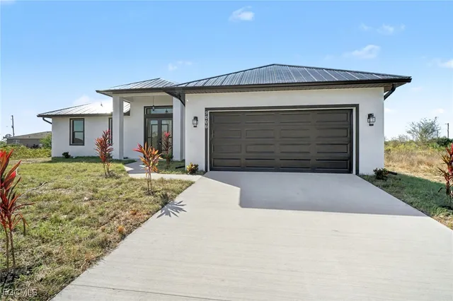 a front view of a house with a yard and garage