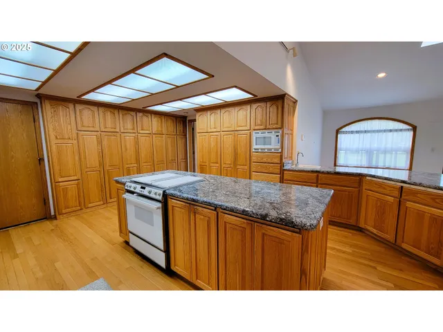 a kitchen with stainless steel appliances granite countertop a sink and wooden cabinets