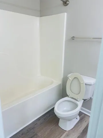 a bathroom with a granite countertop toilet a sink and a mirror