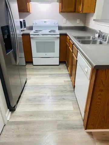 a utility room with wooden floor washer and dryer