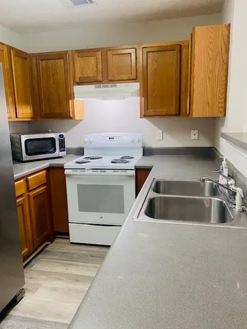 a kitchen with sink a microwave and cabinets