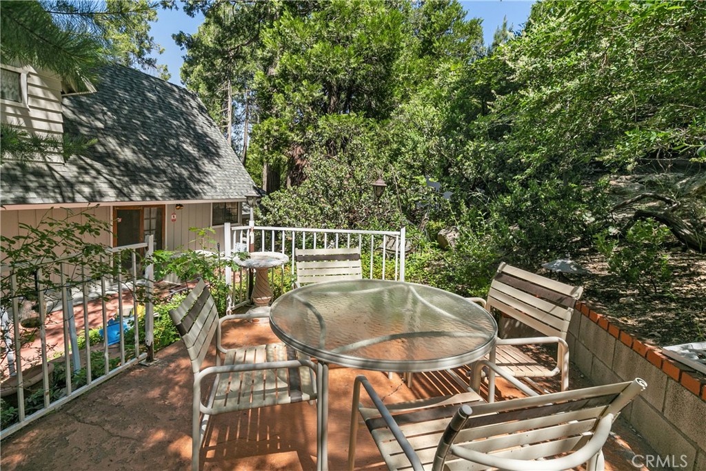 329 Grass Valley Road Lake Arrowhead, CA 92352 - Photo 25 of 31 a view of a patio with table and chairs and potted plants