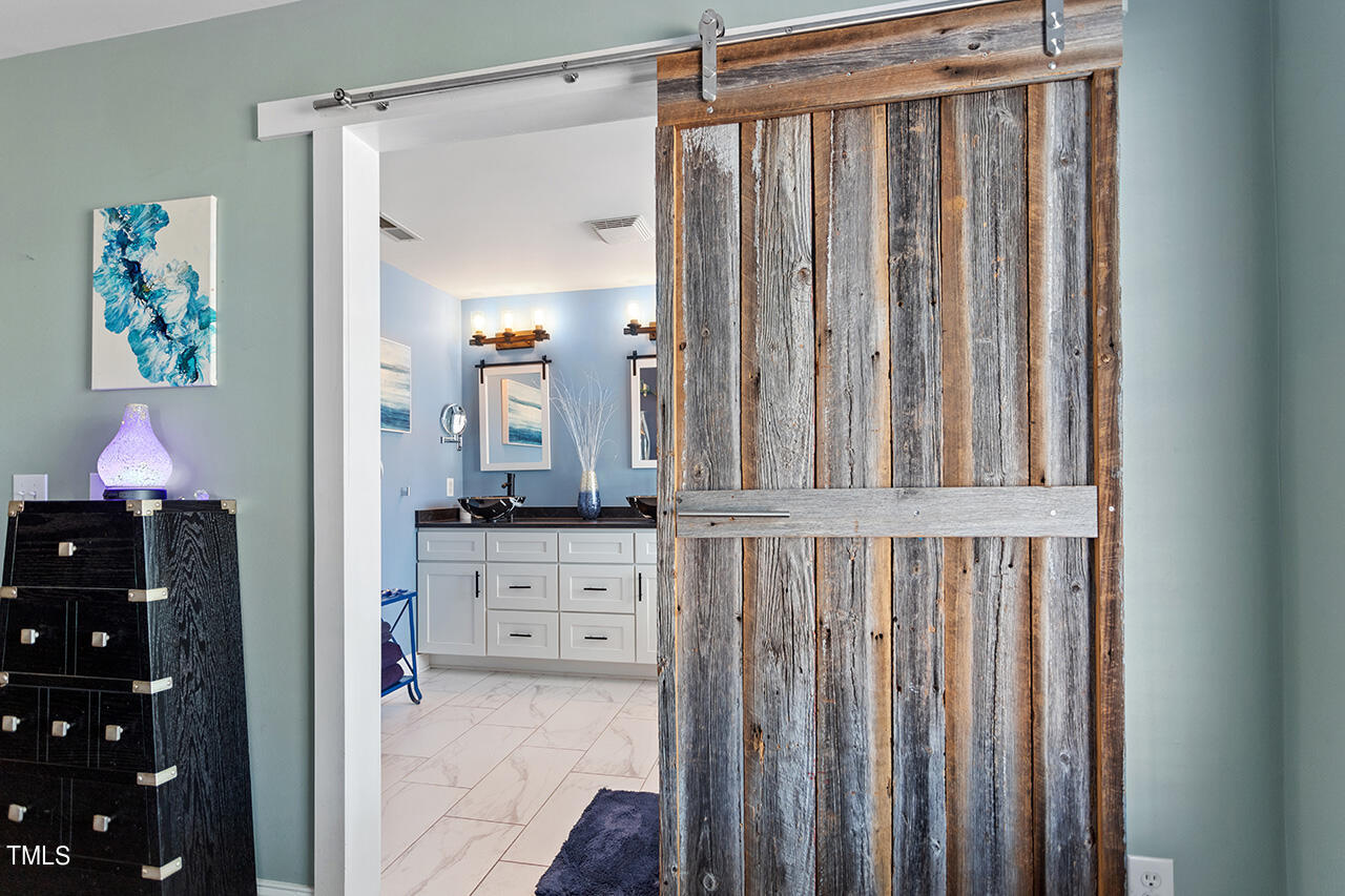 10145 Mizner Lane Raleigh, NC 27617 - Photo 28 of 61 Custom sliding door to primary bath was handcrafted from reclaimed wood