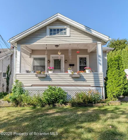 a view of a house with potted plants and a lawn chairs