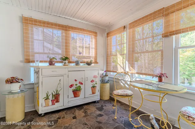 a very nice looking dining room with a large window and furniture