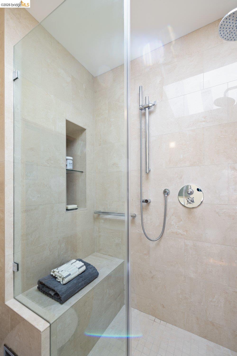 287 Purdue Avenue Kensington, CA 94708 - Photo 49 of 60 Glass-enclosed shower featuring large format wall tiles, a built-in bench, and a recessed niche with shelving