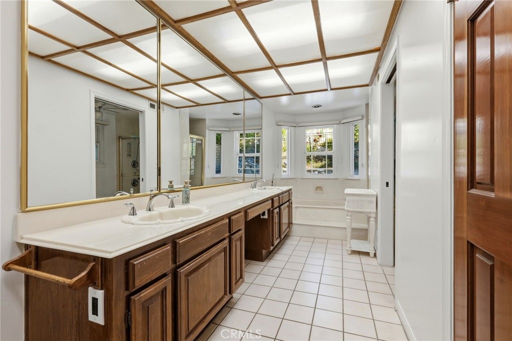 18233 Charlton Lane Porter Ranch, CA 91326 - Photo 18 of 40 a bathroom with a sink a mirror and a shower