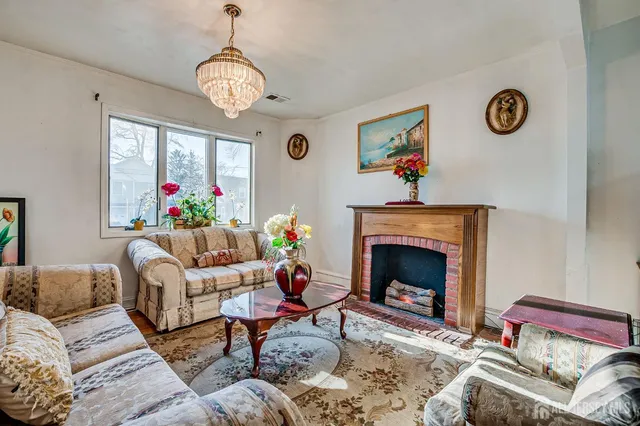 a living room with furniture a clock and a fireplace