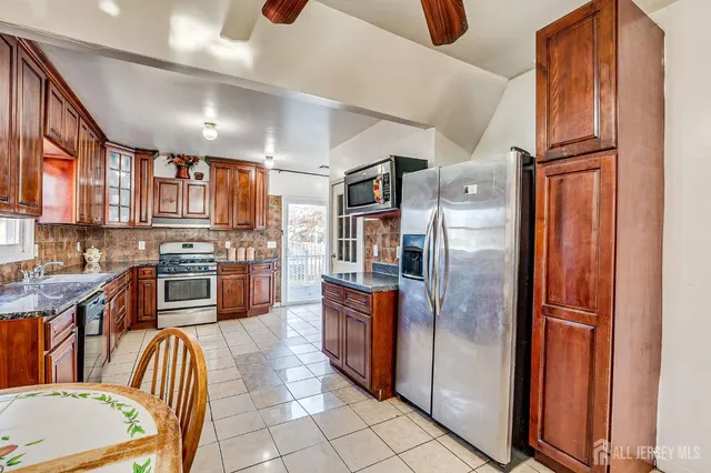 a kitchen with stainless steel appliances granite countertop a refrigerator and a stove top oven