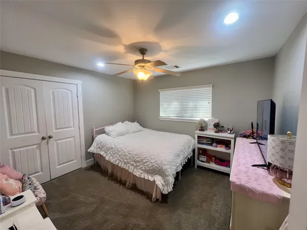 a spacious bedroom with a bed and a chandelier