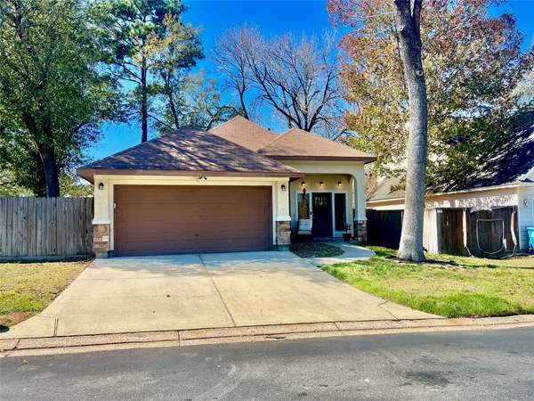 a view of a white house with a large tree and yard