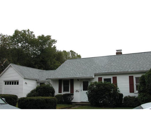 a front view of house with yard and trees around