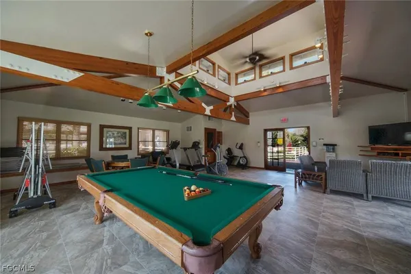 a room with pool table flat screen tv and windows