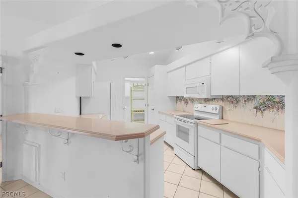 a kitchen with white cabinets appliances and sink