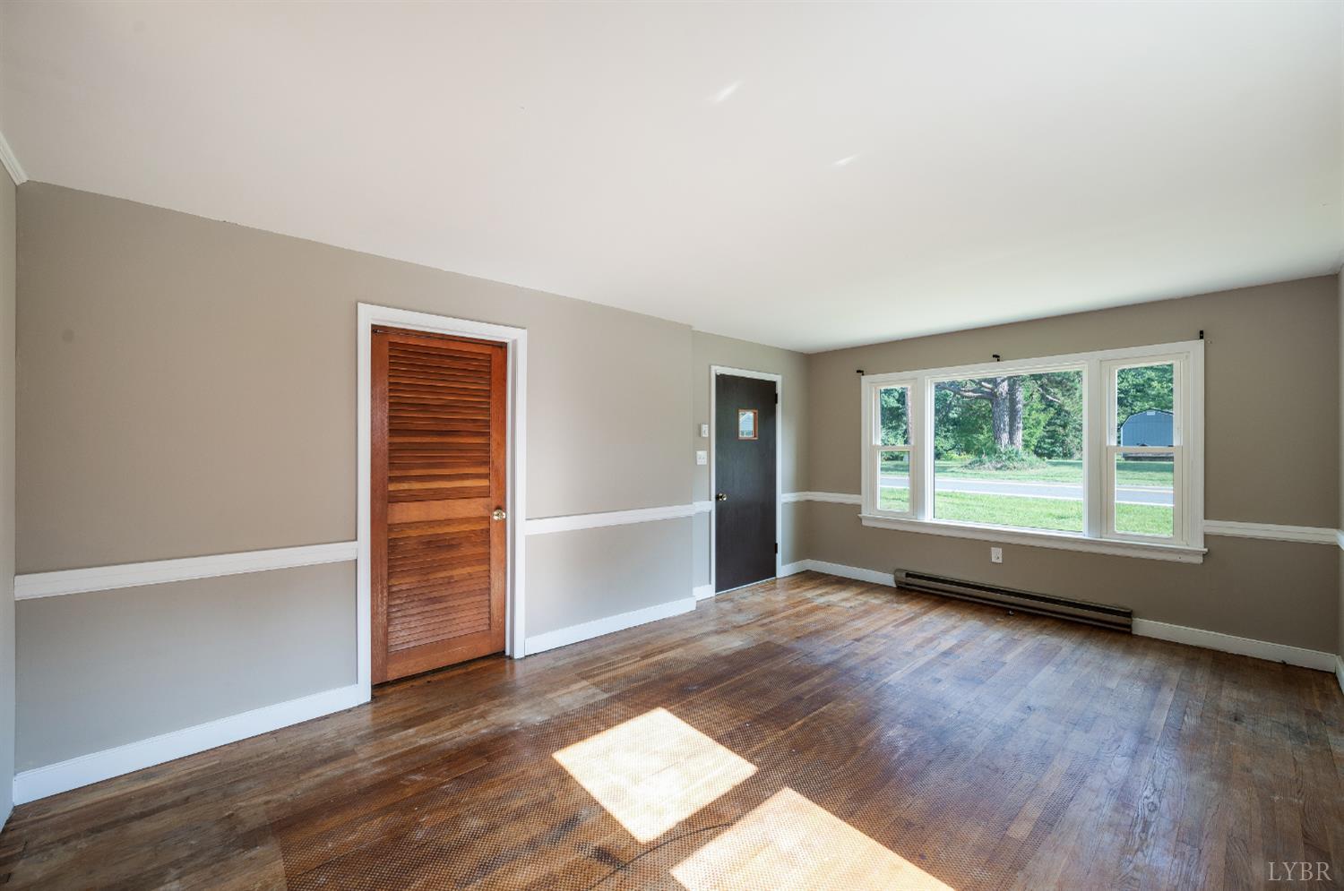 4550 Pumping Station Road Appomattox, VA 24522 - Photo 13 of 34 an empty room with wooden floor and windows