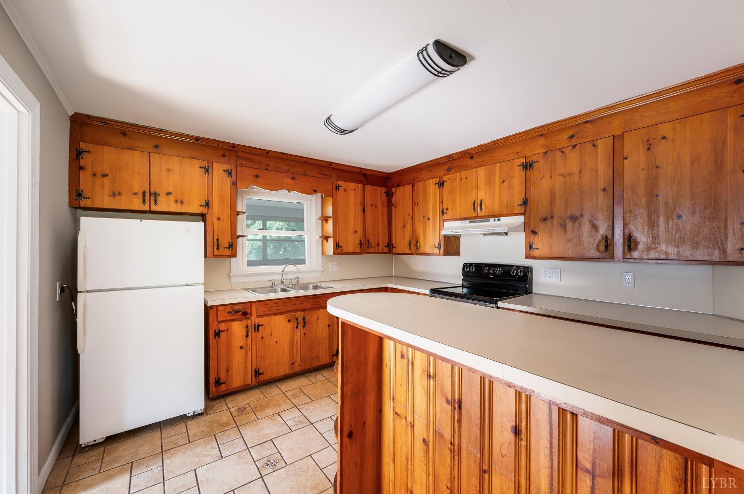 4550 Pumping Station Road Appomattox, VA 24522 - Photo 6 of 34 a kitchen with stainless steel appliances granite countertop a refrigerator a sink dishwasher and wooden cabinets with wooden floor