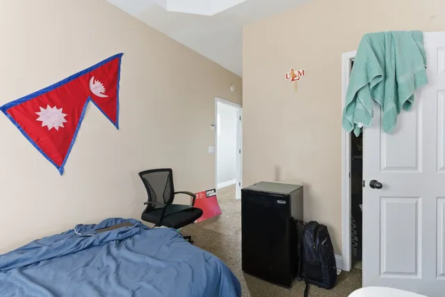 a bedroom with a bed and a painting on the wall