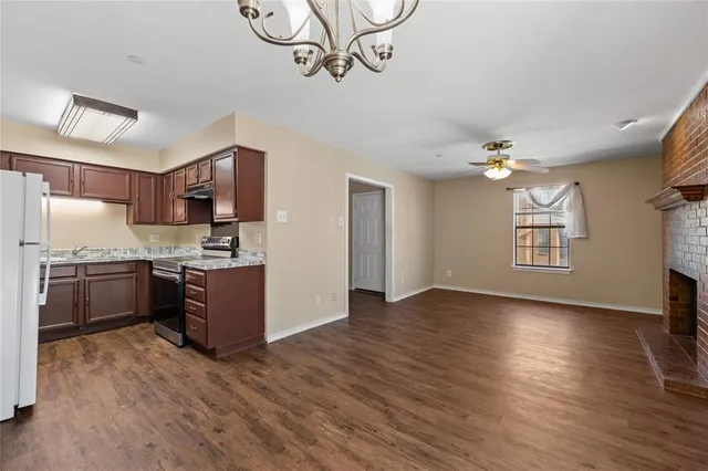 a kitchen with stainless steel appliances granite countertop a sink cabinets and wooden floor