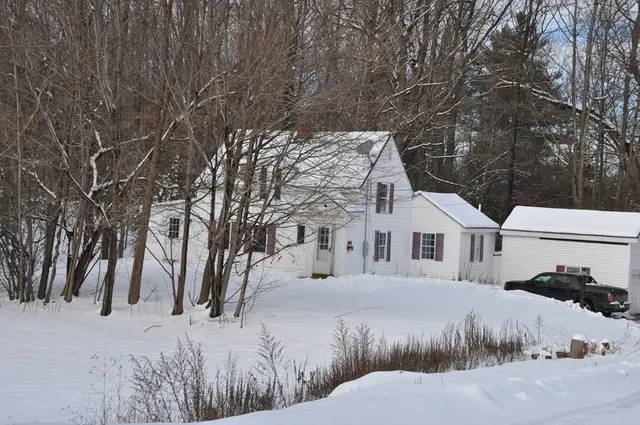 a view of a house with a yard covered in snow