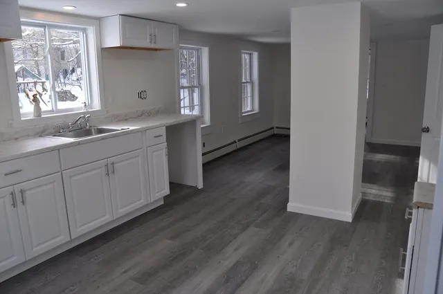 a view of a kitchen with wooden floor and electronic appliances