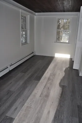 wooden floor in an empty room with a window