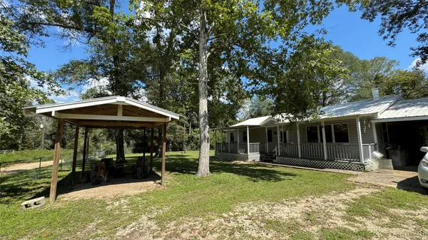 a view of a patio with table and chairs under an umbrella