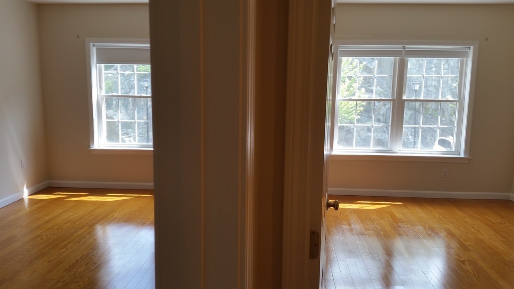 974 Main Street, Unit 25 Wakefield, MA 01880 - Photo 11 of 28 a view of an empty room with wooden floor and a window