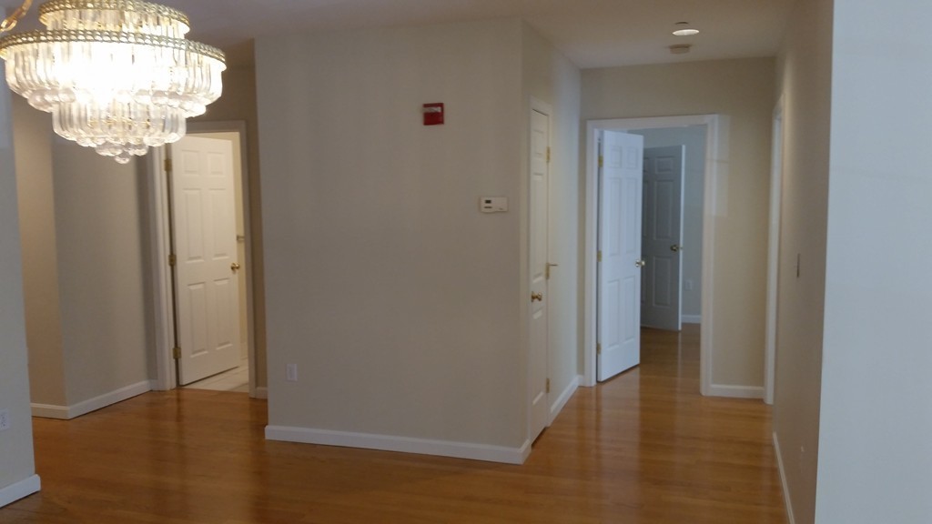 974 Main Street, Unit 25 Wakefield, MA 01880 - Photo 13 of 28 a view of a hallway with wooden floor and chandelier
