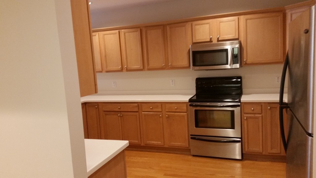974 Main Street, Unit 25 Wakefield, MA 01880 - Photo 18 of 28 a kitchen with granite countertop white cabinets and stainless steel appliances
