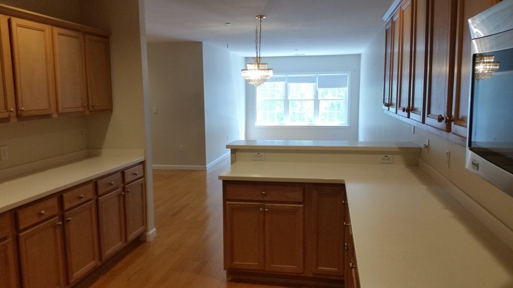 974 Main Street, Unit 25 Wakefield, MA 01880 - Photo 20 of 28 a kitchen with a sink and a refrigerator