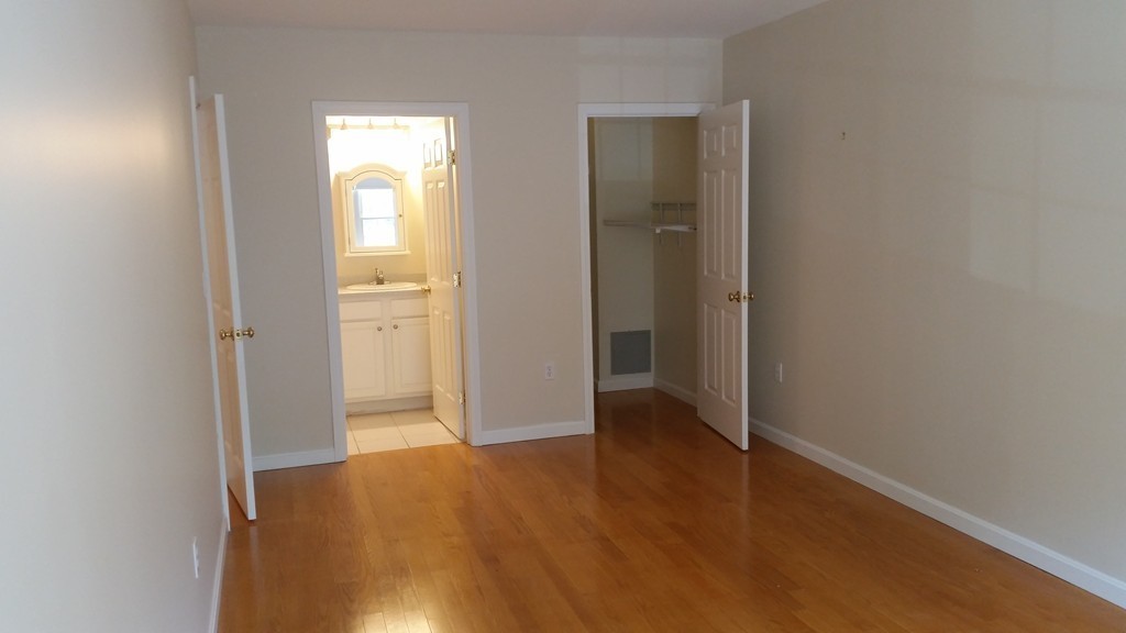 974 Main Street, Unit 25 Wakefield, MA 01880 - Photo 10 of 28 an empty room with wooden floor and windows