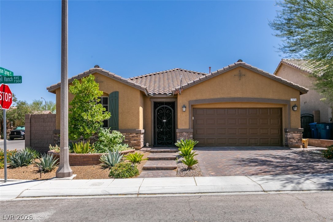 7375 Campbell Ranch Avenue Las Vegas, NV 89179 - Photo 2 of 45 A well-maintained desert landscape frames this welcoming corner residence with a paver driveway.