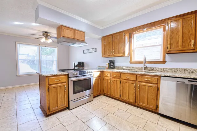 a kitchen with stainless steel appliances granite countertop a stove a sink and a microwave