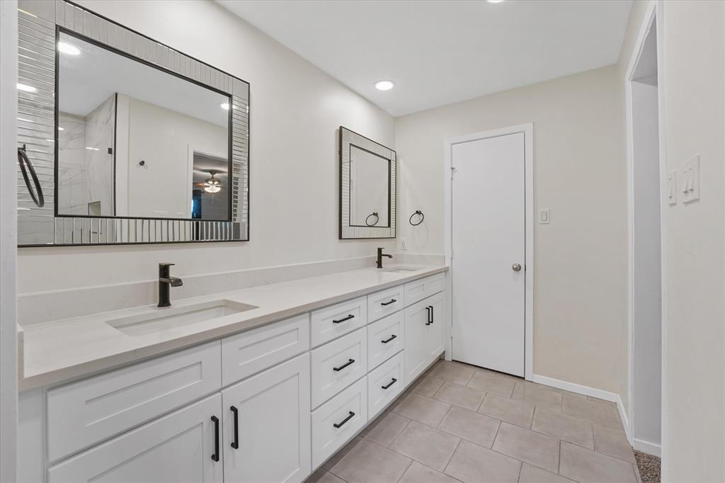 4007 Ridgebrook Drive Arlington, TX 76015 - Photo 14 of 18 Dual vanity with white cabinetry and matte black hardware, featuring integrated sinks and light-toned countertops