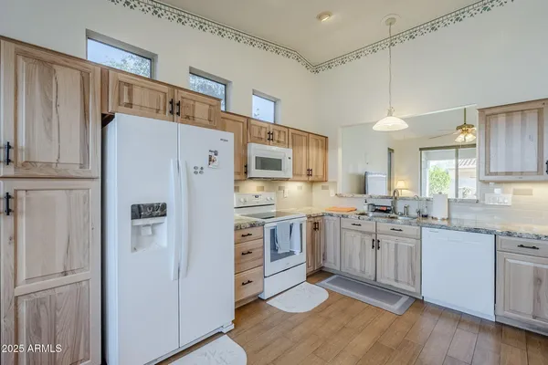a kitchen with granite countertop a sink cabinets and wooden floor
