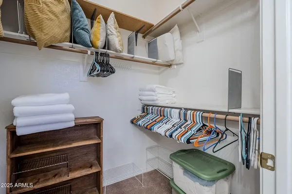 a bedroom with a bed and a lamp on dresser