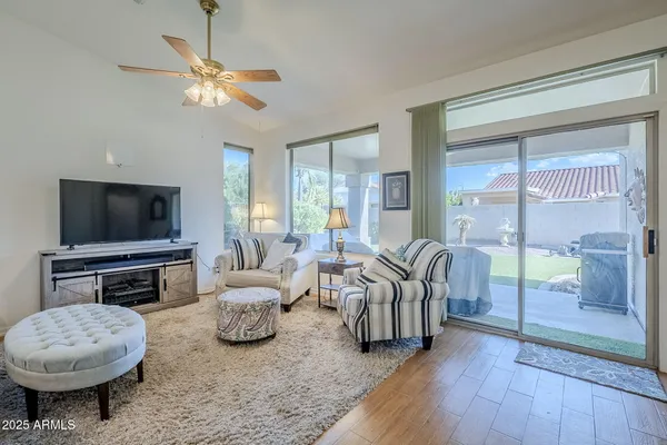 a living room with furniture a flat screen tv and a large window