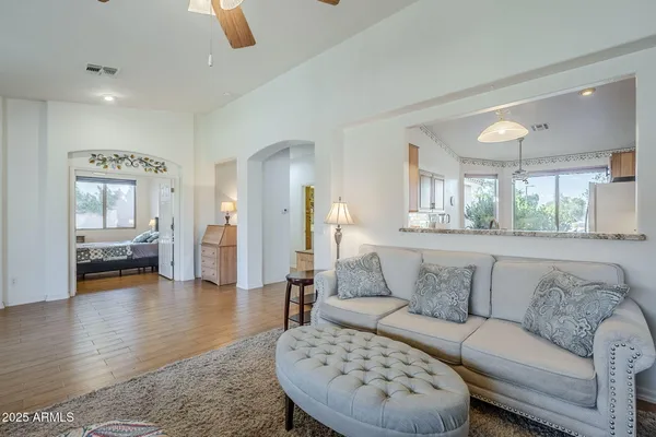 a living room with furniture ceiling fan and a window