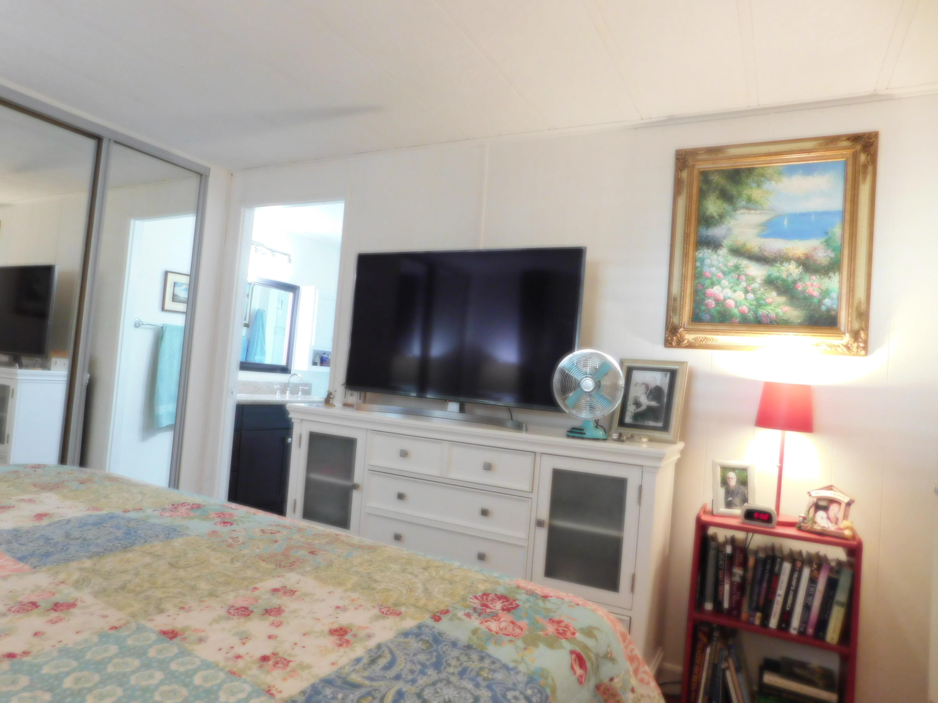 51555 Monroe Street, Unit 52 Indio, CA 92201 - Photo 22 of 42 a bedroom with a bed and a flat screen tv in it