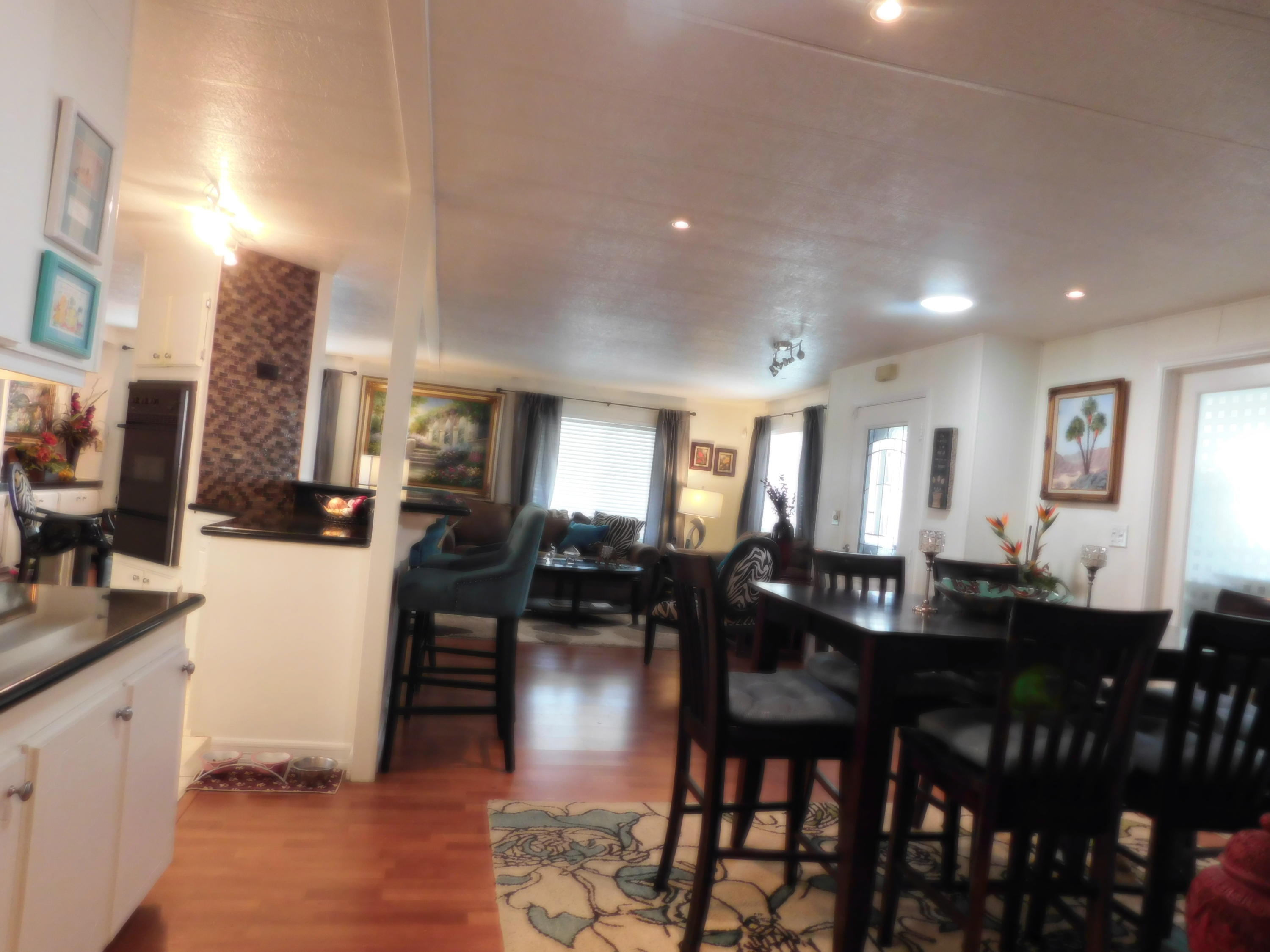 51555 Monroe Street, Unit 52 Indio, CA 92201 - Photo 23 of 42 a dining room with stainless steel appliances kitchen island granite countertop a dining table chairs and a refrigerator