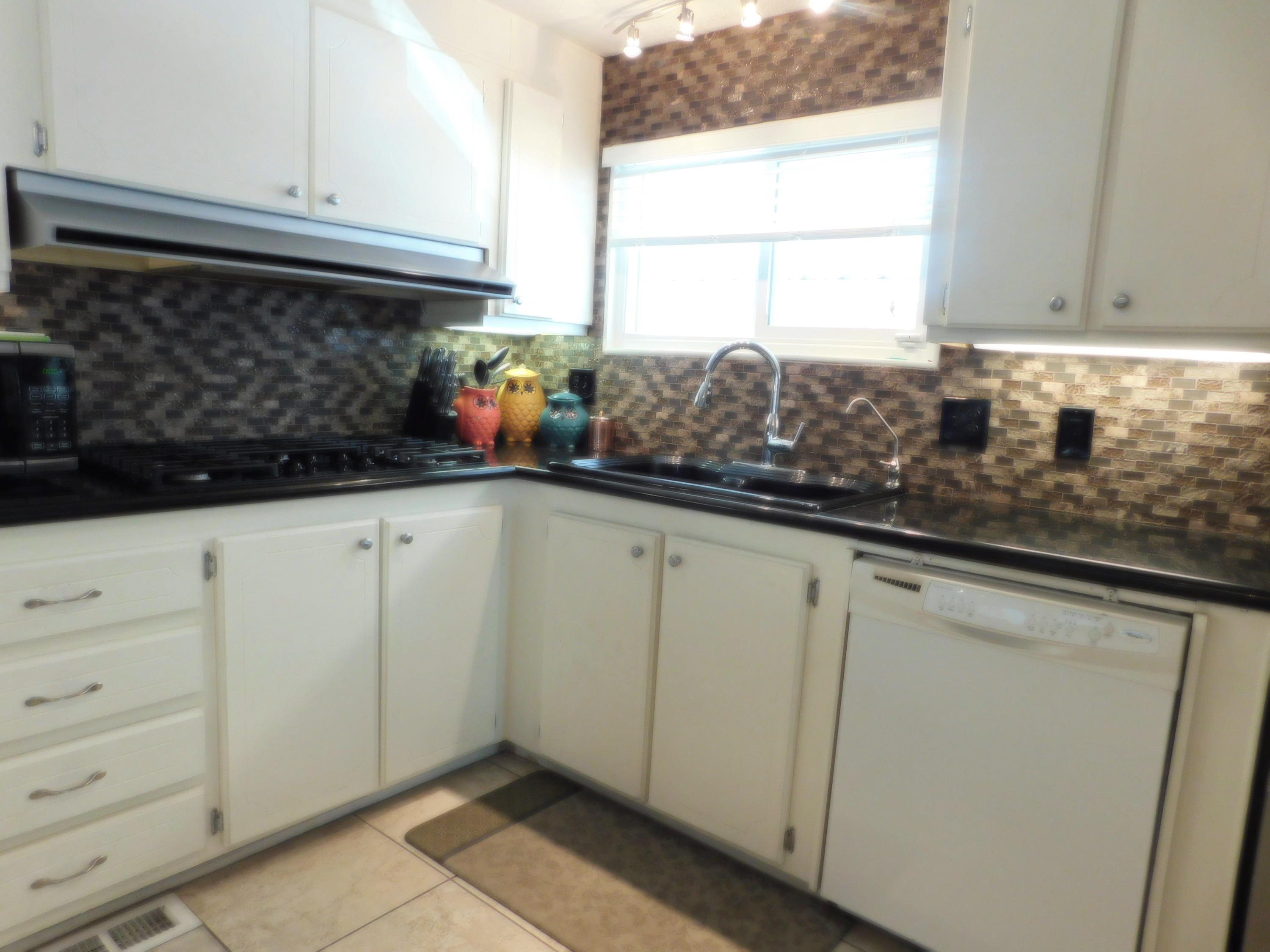 51555 Monroe Street, Unit 52 Indio, CA 92201 - Photo 8 of 42 a kitchen with white cabinets and window