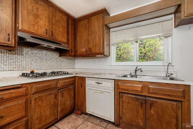 a kitchen with granite countertop cabinets stainless steel appliances a sink and a window