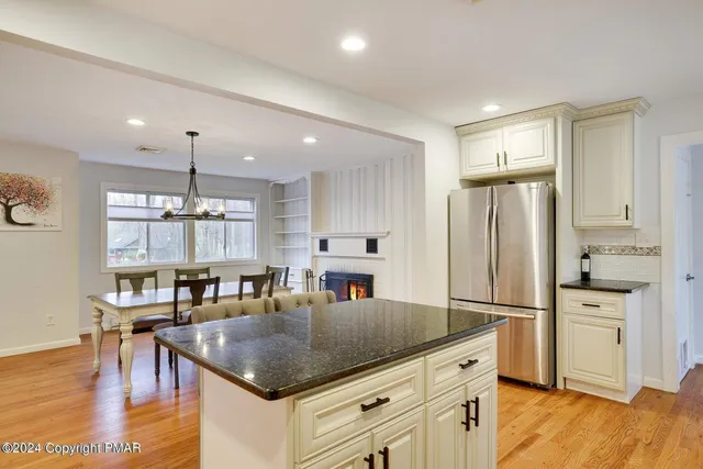 a kitchen with stainless steel appliances granite countertop a refrigerator a stove and a wooden floors