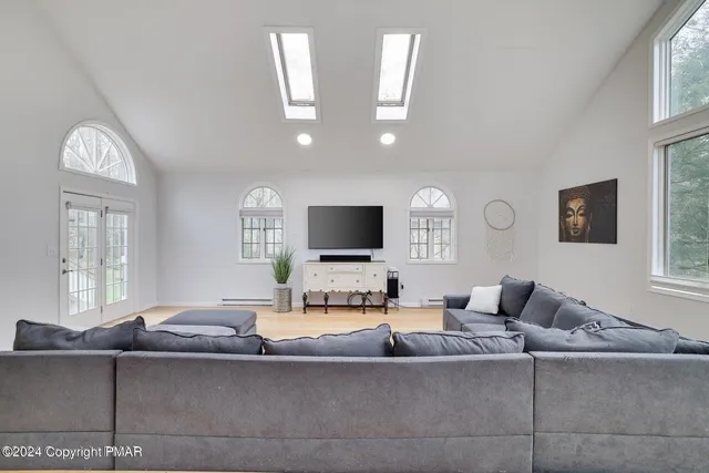 a living room with furniture a large window and a flat screen tv